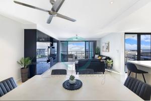 una sala da pranzo e un soggiorno con ventilatore a soffitto di ZEN AT ARKABA 3BR Luxury Waterfront Apt Pool + BBQ a Darwin