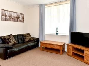 uma sala de estar com um sofá de couro preto e uma televisão de ecrã plano em Pass the Keys Central Swansea townhouse 4B Mins from everything em Swansea