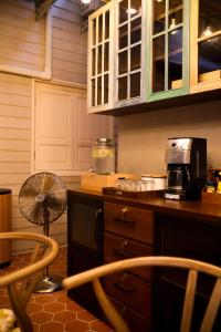 a kitchen with a counter with a fan and a microwave at Tali-Yailai Hostel in Pattaya Central