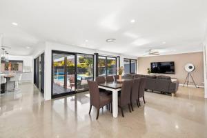 een eetkamer en een woonkamer met een tafel en stoelen bij Ultra Modern & Relaxing Inner City 4bed House - with a Private Pool - 10mins walk to Beach in Gold Coast