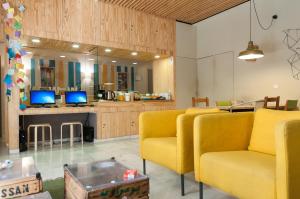 a living room with two yellow chairs and a table at The Nomad Hostel&Pension in Seville
