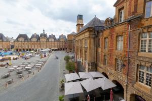 een straat met tafels en parasols in een stad bij Charleville-Mézières: belle vue Place Ducale in Charleville-Mézières