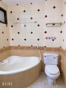 a bathroom with a tub and a toilet and a sink at Saigon Cozy House & coffee in Ho Chi Minh City