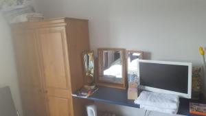 einen Schreibtisch mit einem Computermonitor und einem Spiegel in der Unterkunft Pat's Place in Ballaghaderreen