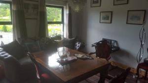 Pat's Place في Ballaghaderreen: غرفة معيشة مع طاولة خشبية وأريكة