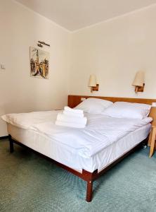 a bedroom with a large bed with white sheets at Hotel Zajazd Kultury, dawniej Pocztowy in Zielona Góra