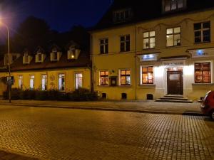 a building on a street at night at Hotel Zajazd Kultury, dawniej Pocztowy in Zielona Góra