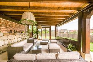 an outdoor patio with couches and chairs and a stone wall at POSADA El ABUELO DE LA CACHAVA in Gajano