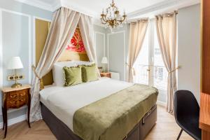 a bedroom with a large bed and a chandelier at Luxury 4 bedrooms 3 bathrooms apartment - Louvre in Paris