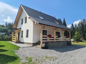 a white house with a black roof at Domek pod Złotym Groniem in Istebna