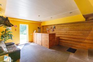 sala de estar con paredes amarillas y sofá en Viesu nams “Dimantu ferma” en Ikšķile