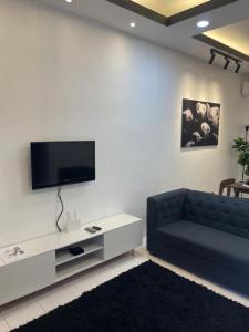 a living room with a couch and a flat screen tv at ExHome Terengganu in Kuala Terengganu
