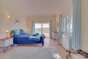 a bedroom with a blue bed and a window at Casa dos Sonhos by Portucasa in São Brás de Alportel +37 photos