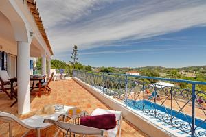 a balcony of a house with a table and chairs at Casa dos Sonhos by Portucasa in São Brás de Alportel
