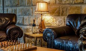 una sala de estar con 2 sillas de cuero y un tablero de ajedrez en The Belgrade Hills Rooms and Suites, en Belgrado