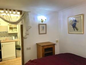 a bedroom with a bed and a table and a kitchen at Cosy comfortable Slice of Heaven Annex in Porlock in Porlock