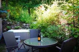 a bottle of beer sitting on a table on a patio at Pine cottage with private hot tub in Upper Hulme