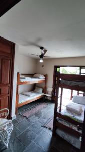 a room with bunk beds and a ceiling fan at Felicidade in front sea in Saquarema