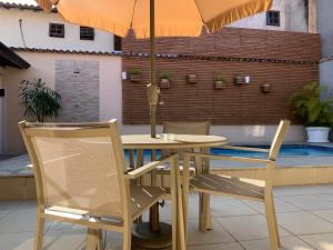 a table and chairs with an umbrella on a patio at Pousada da Praia in Paraty