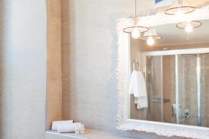 baño con espejo y lavabo en Boutique Hotel Villa Sarnia, en San Nazzaro