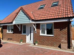 a red brick house with an orange roof at Pass the Keys By the Beach Brand New Holiday home in Littlestone-on-Sea
