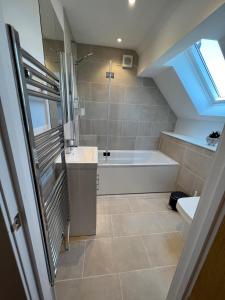 a bathroom with a shower and a tub and a sink at Pass the Keys By the Beach Brand New Holiday home in Littlestone-on-Sea