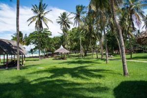 un campo de hierba con palmeras y el océano en Muthu Nyali Beach Hotel & Spa, Nyali, Mombasa en Mombasa