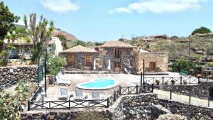 a villa with a swimming pool and a house at Caserio rural antiguo con espectacular piscina y Wifi en San Miguel de Abona, Tenerife Sur in San Miguel de Abona