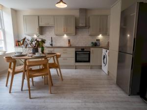 a kitchen with a table and chairs and a refrigerator at Pass the Keys Luxury 2 bed apartment in Nottingham city centre in Nottingham