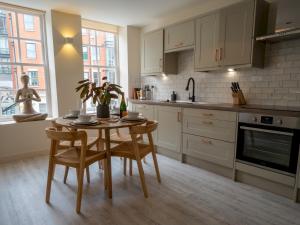 a kitchen with a table and chairs and a sink at Pass the Keys Luxury 2 bed apartment in Nottingham city centre in Nottingham