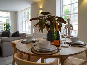 a dining room table with glasses and a bottle of wine at Pass the Keys Charming Central Apartment Steps from Nottingham's Best in Nottingham