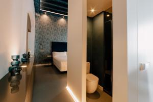 une salle de bain avec un lit et des toilettes dans une chambre dans l'établissement Casa del Cardenal, à Cordoue
