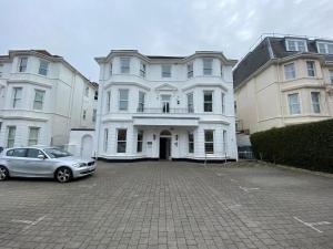 a car parked in front of a large white house at Cosy Beachfront Bournemouth 3-Bedroom 3-Bathroom Free Parking Free WiFi in Bournemouth