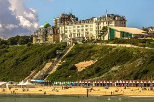 a large building on top of a hill with a beach at Cosy Beachfront Bournemouth 3-Bedroom 3-Bathroom Free Parking Free WiFi in Bournemouth