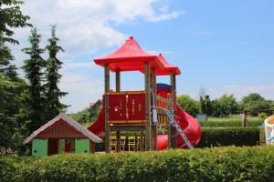 einen Spielplatz mit einer roten Rutsche in einem Park in der Unterkunft Ferienwohnanlage Schwabe mit Schwimmbad in Rerik