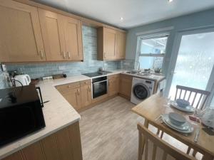 a kitchen with wooden cabinets and a stove top oven at Beautiful Peebles Bungalow in Peebles