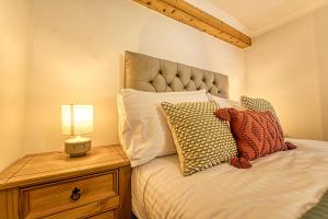 a bedroom with a bed with a lamp on a night stand at Guest Homes - London Road Cottage in Worcester