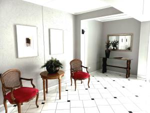 a room with two chairs and a table and a mirror at Hotel Princeton in Piracicaba