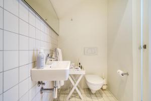 a white bathroom with a sink and a toilet at Tuishuisie in Stellenbosch