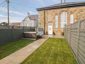 a backyard of a house with a fence at Sardis Chapel 1 in Bodorgan