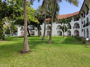 un edificio con palme di fronte ad esso di Muthu Nyali Beach Hotel & Spa, Nyali, Mombasa a Mombasa