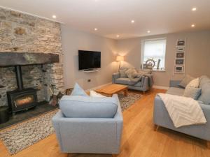 a living room with a couch and a fireplace at Fishermans Cottage in Bodorgan