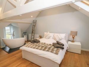 a bedroom with a large bed and a bath tub at Fishermans Cottage in Bodorgan
