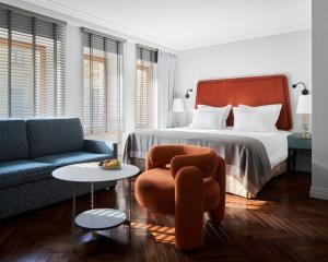 a bedroom with a bed and a couch and a chair at Helvetia Hotel in Saint Petersburg