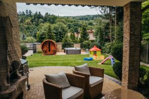 a patio with chairs and a backyard with a playground at Zarabie Residence in Myślenice +94 photos