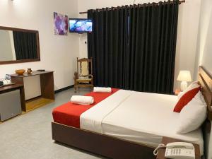 1 dormitorio con 1 cama y TV en Athyantha Resort, en Anuradhapura