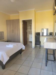 a hotel room with a bed and a kitchen at Mogale Royal Gardens in Polokwane