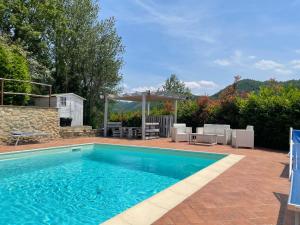 a swimming pool with chairs and a gazebo at Il Borghetto di Pedana in Città di Castello