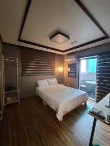 a bedroom with a bed and a large window at TreehouseUnseo GuestHouse in Incheon