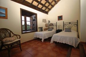 - une chambre avec deux lits, une chaise et une fenêtre dans l'établissement Casa Rural Vera De La Hoya, à San Miguel de Abona